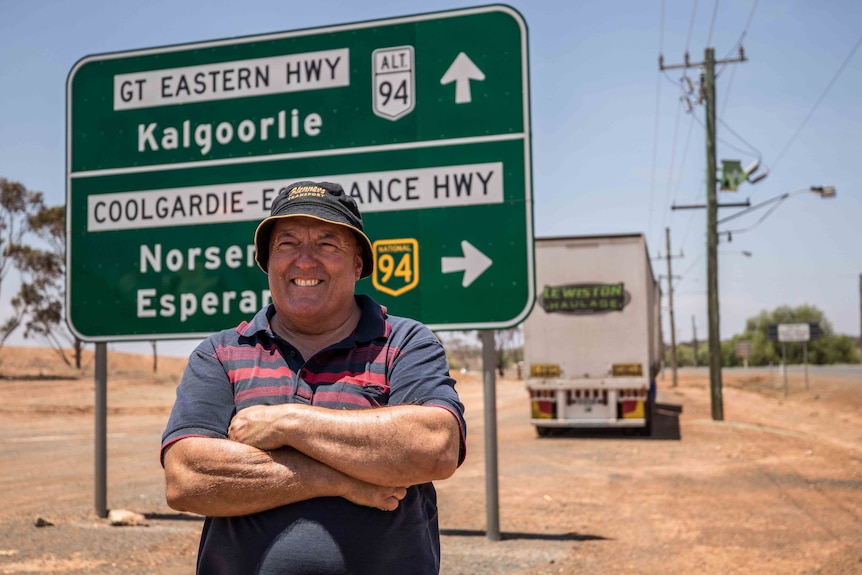 Truck driver standing in front of road train.