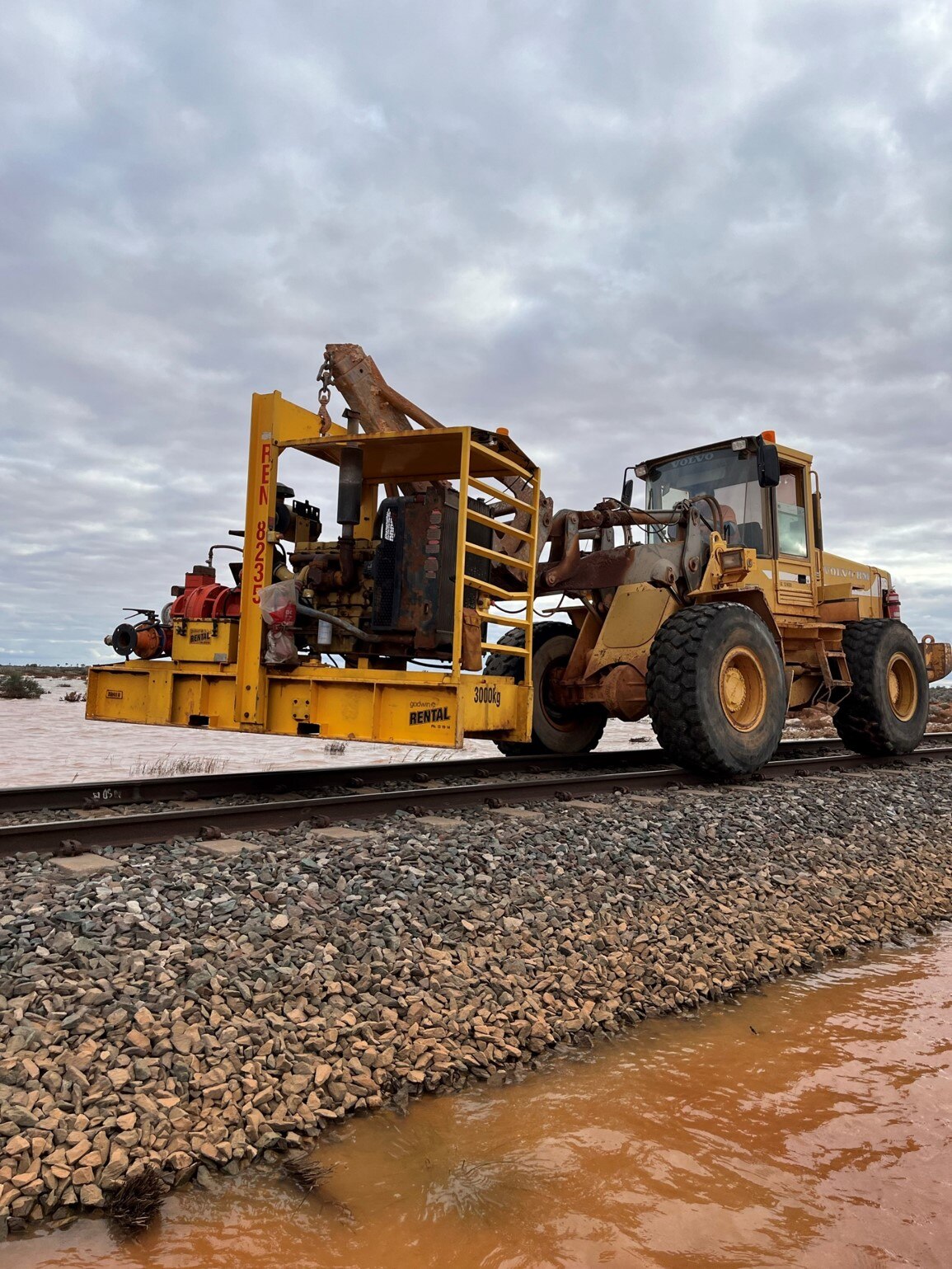 Crew working to repair rail line during floods. 