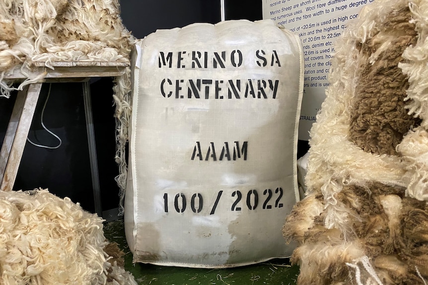 A wool bale sits next to piles of wool. 