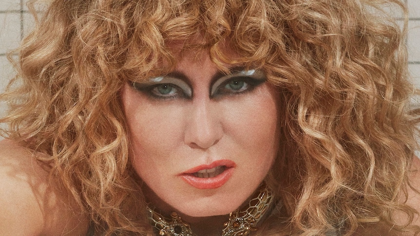 Close up of a woman with curly hair lying on her front, snarling at the camera