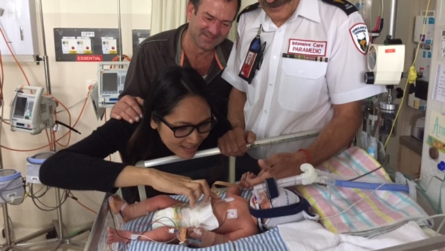 Andrew and Siripa Day, with paramedic Peter James, admire baby Armando Sonny Day.