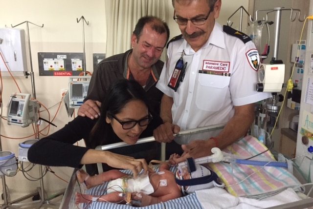 Andrew and Siripa Day, with paramedic Peter James, admire baby Armando Sonny Day