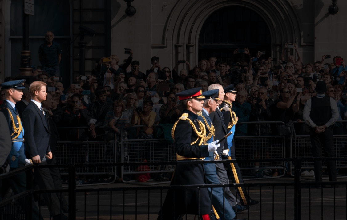 The royal procession is seen again, but this time with the crowd faded out