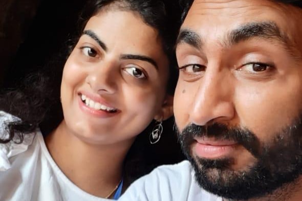 A young Indian couple in a selfie wearing white t-shirts.
