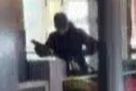 Blurry picture of man in black holding a gun