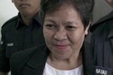 Maria Exposto seen with security staff at a Malaysian court.