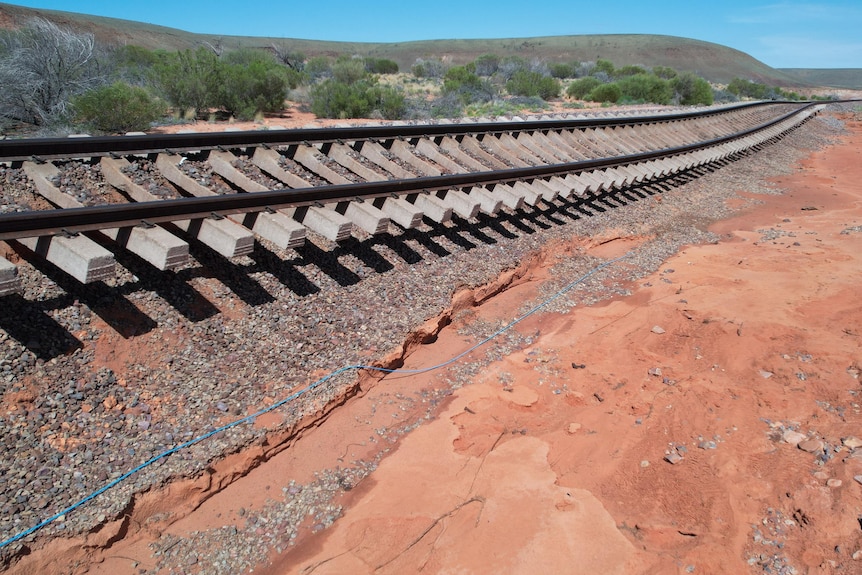 a section of rail line damaged and on its side as a result of flooding.