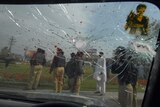 Pakistani police mill around wrecked car