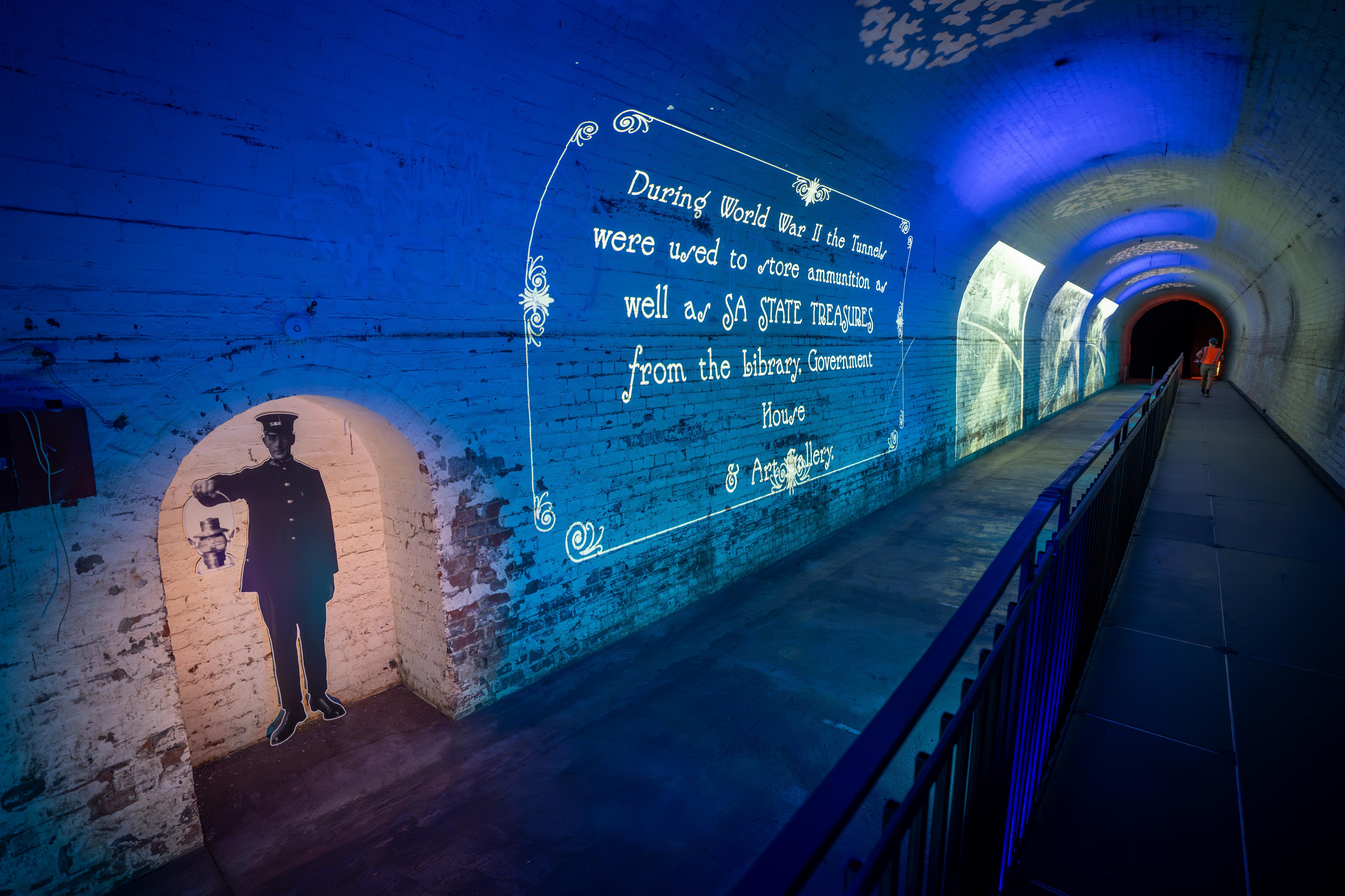 Historic photos and history about World War II projected on tunnel walls