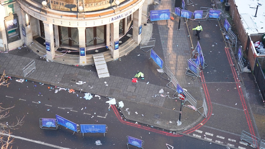 An aerial shot of a street filled with broken fences and rubbish outside a concert venue. 