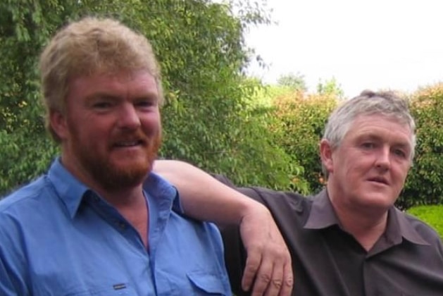 Two men standing in a backyard