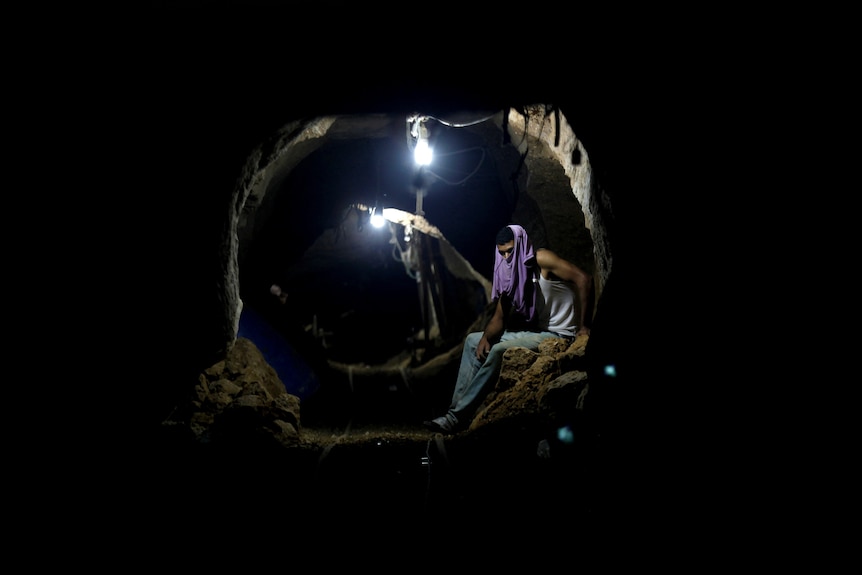 A Palestinian worker rests inside a smuggling tunnel.