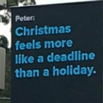 A digital billboard reads: "Christmas feels more like a deadline than a holiday"