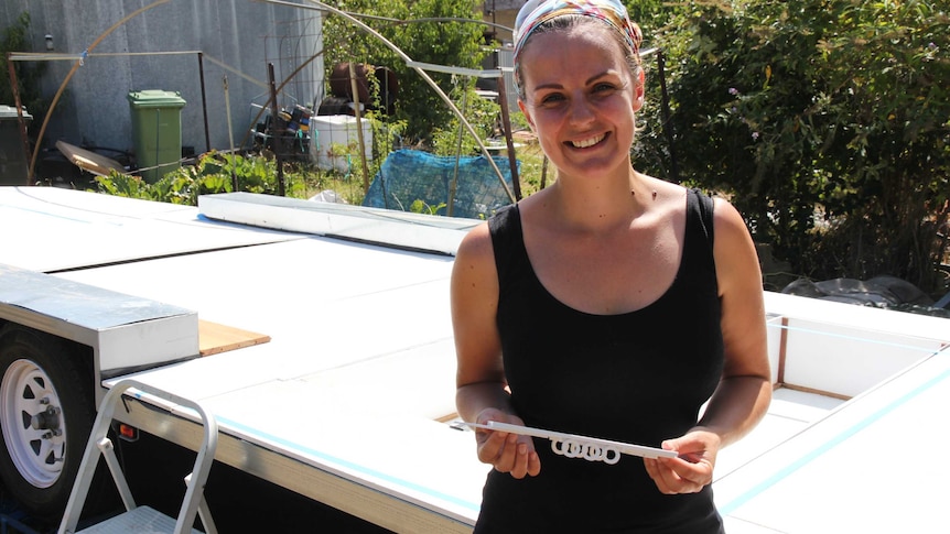 Amy Stevens stands in front of the foundation base that will make up her tiny home.