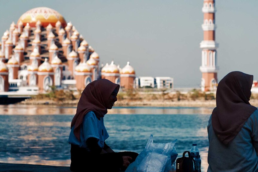 Two women with mosque in the background