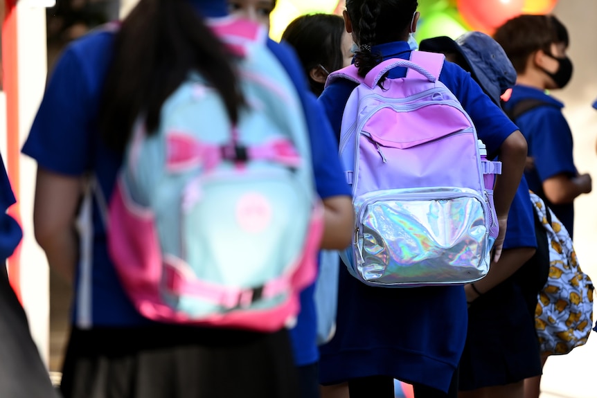 students entering school with backpacks
