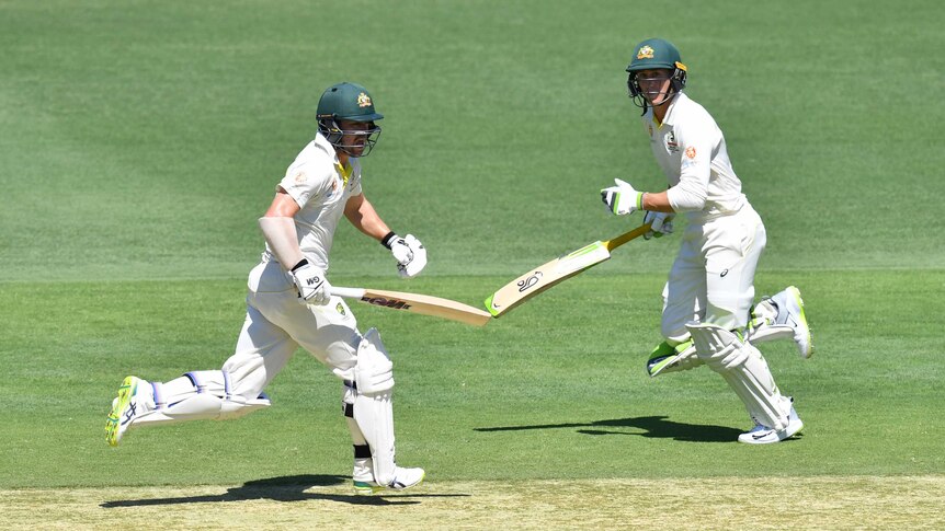 Australia batsmen Travis Head and Marnus Labuschagne run between wickets during a Test against Sri Lanka at the Gabba.