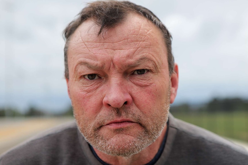 Close-up of a middle aged man outside.