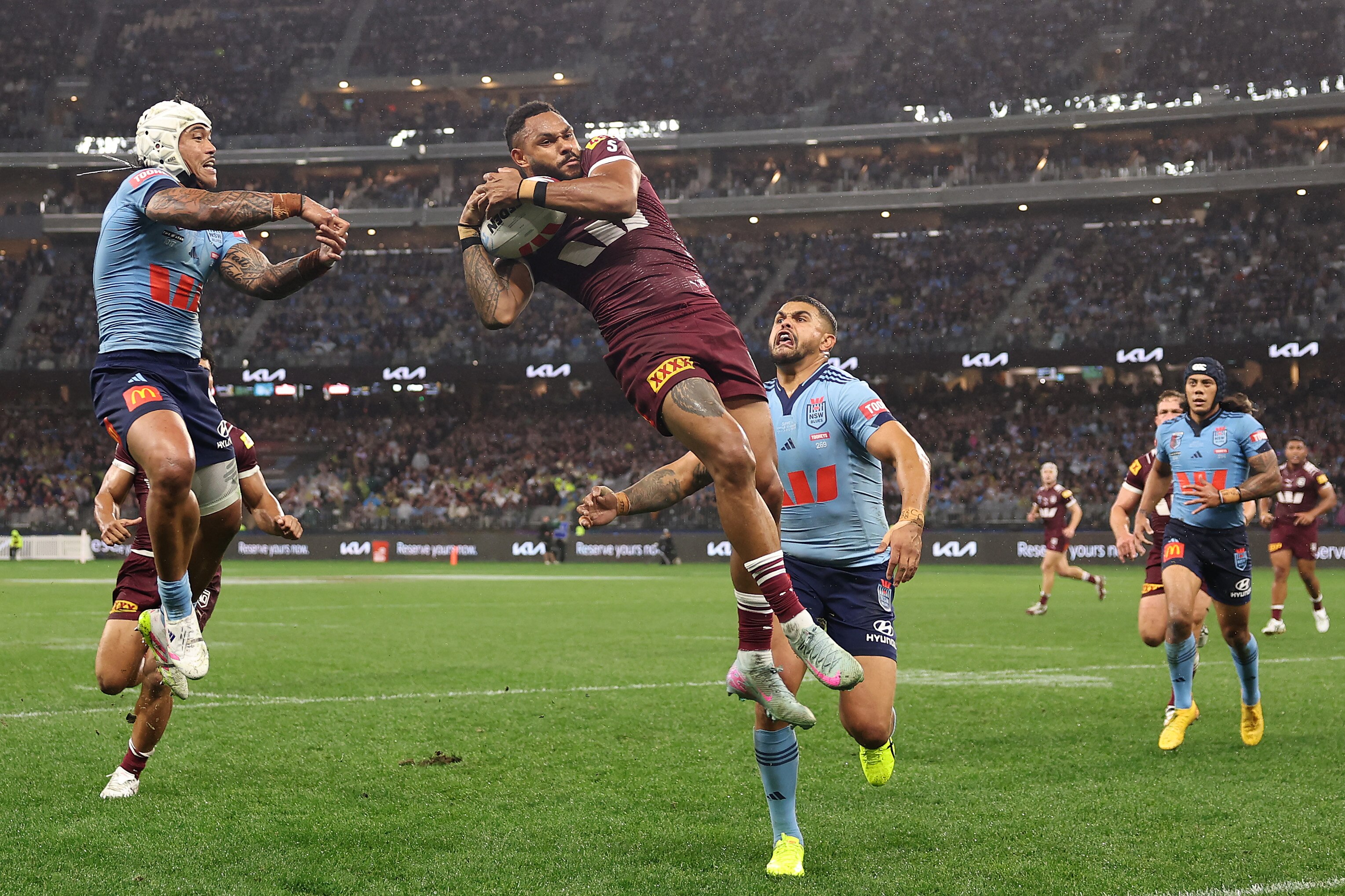 Hamiso Tabuai-Fidow catches the ball, after jumping in the air, with two defenders around him