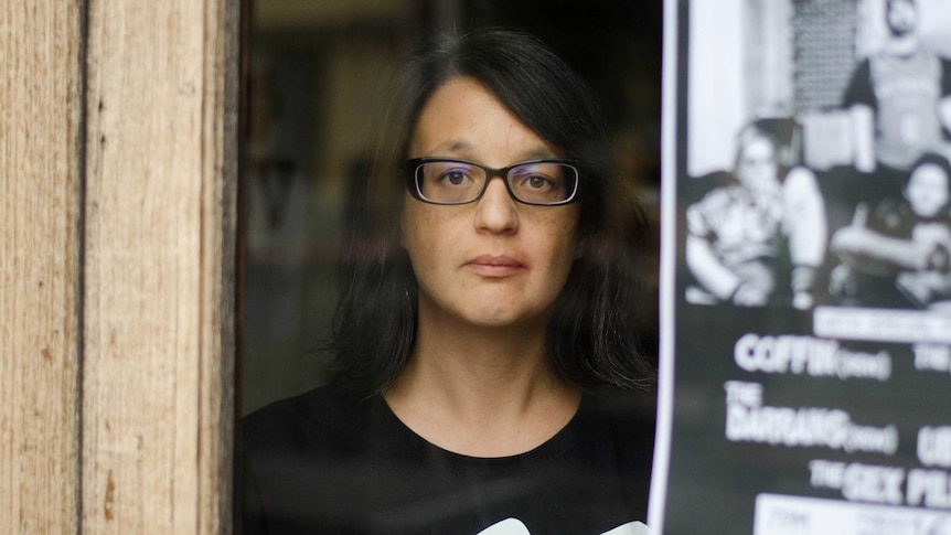 Natalie Pestana looks through the window of a bar in Melbourne