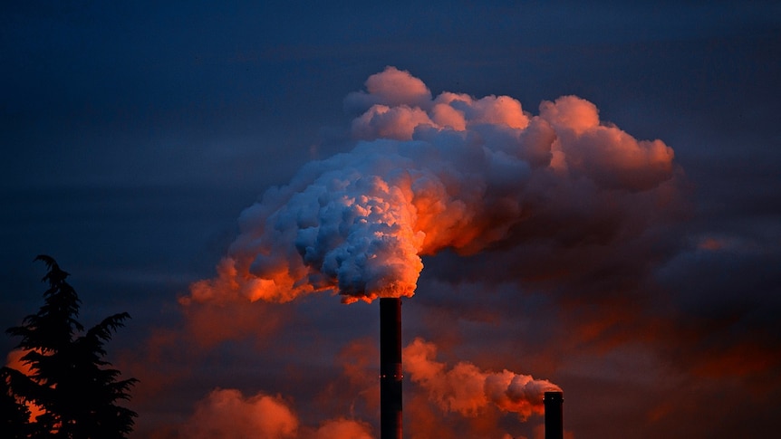 smoke leaves a chimney of a power station at night