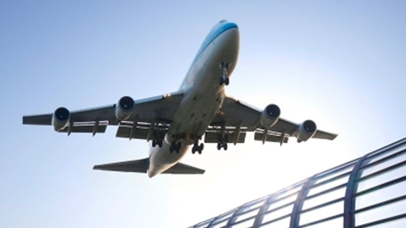 An aeroplane taking off above a building