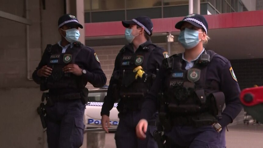 Three police officers wearing masks walk the streets of Fairfield.