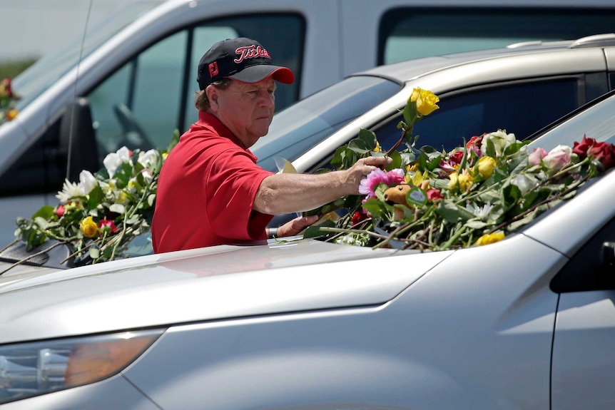 A man leaves flowers on cars believed to belong to victims of the duck boat accident.
