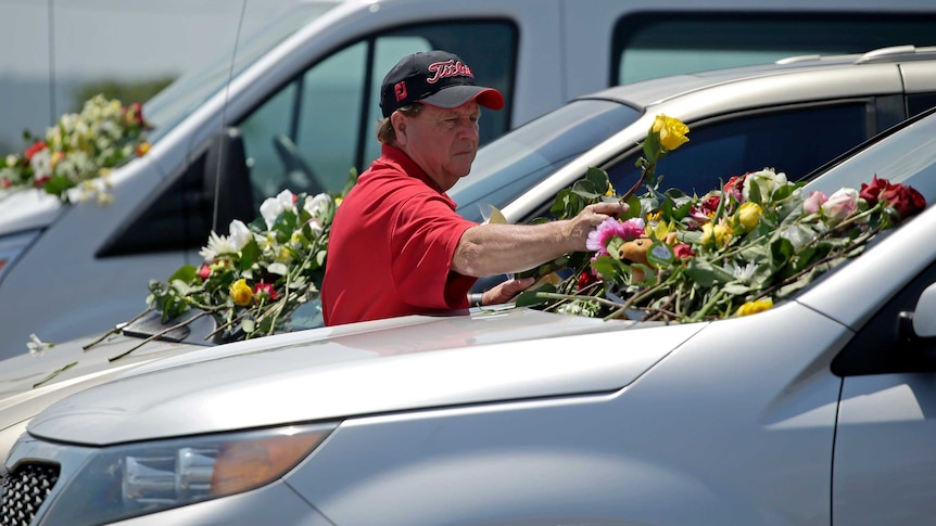 A man leaves flowers on cars believed to belong to victims of the duck boat accident.