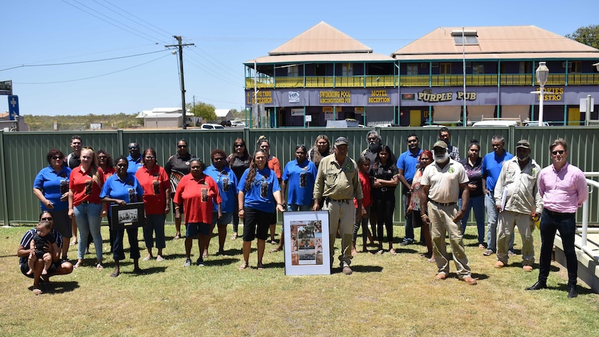 A group of Indigenous people standing on a lawn after an important native title decision.