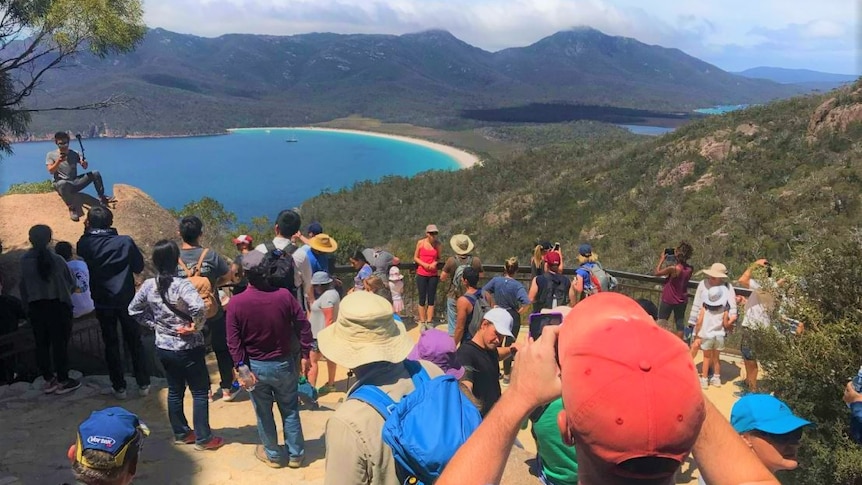 Tourists and sightseers at a coastal lookout.