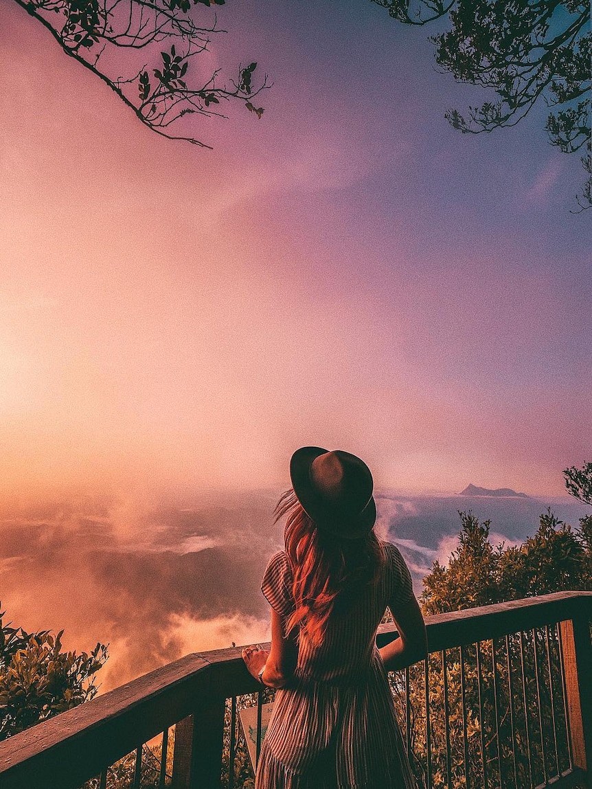 Girl stands looking at view