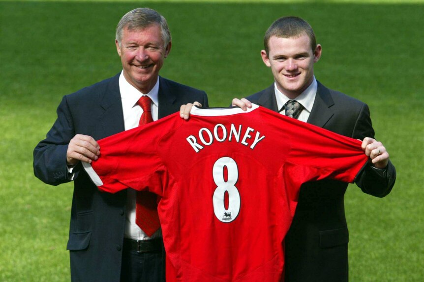 Wayne Rooney stands with Sir Alex Ferguson after signing for Manchester United on September 1, 2004