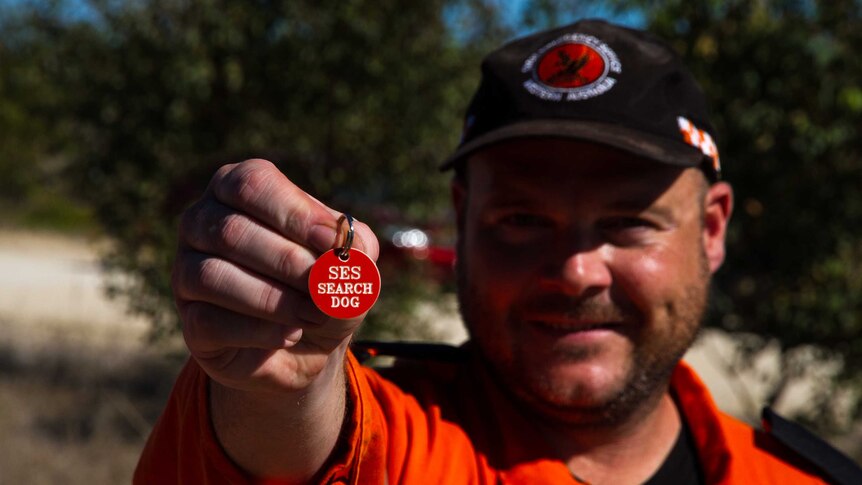 Andrew King holds up the SES search dog tag.