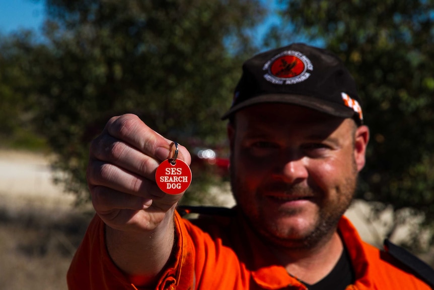 Andrew King holds up the SES search dog tag.