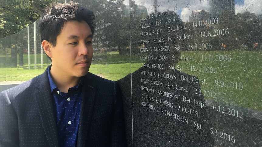 Alpha Cheng looks at his father's name on the NSW Police memorial wall.