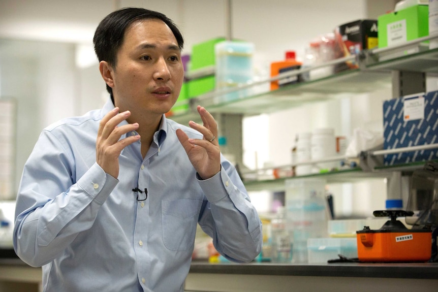 He Jiankui gestures with his hands while speaking during an interview.