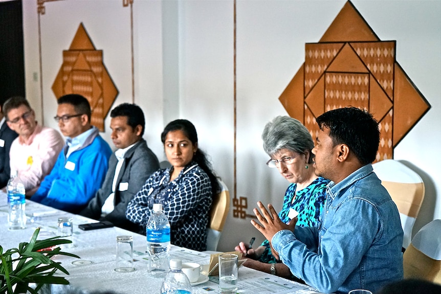 Australian and Nepalese people sitting around a conference table