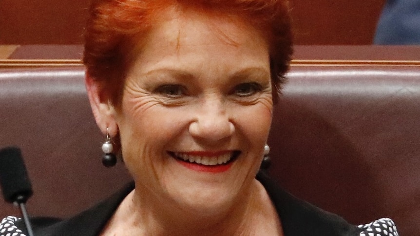 A fair-skinned woman with red hair smiling.