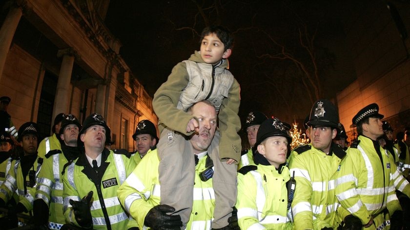 A child sits on the shoulders of a London policeman during a pro-Palestinian protest