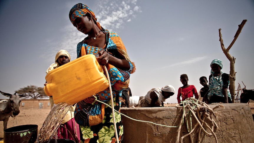 A woman refills her bucket from a well in the drought-stricken south of Mauritania on February 20, 2012.