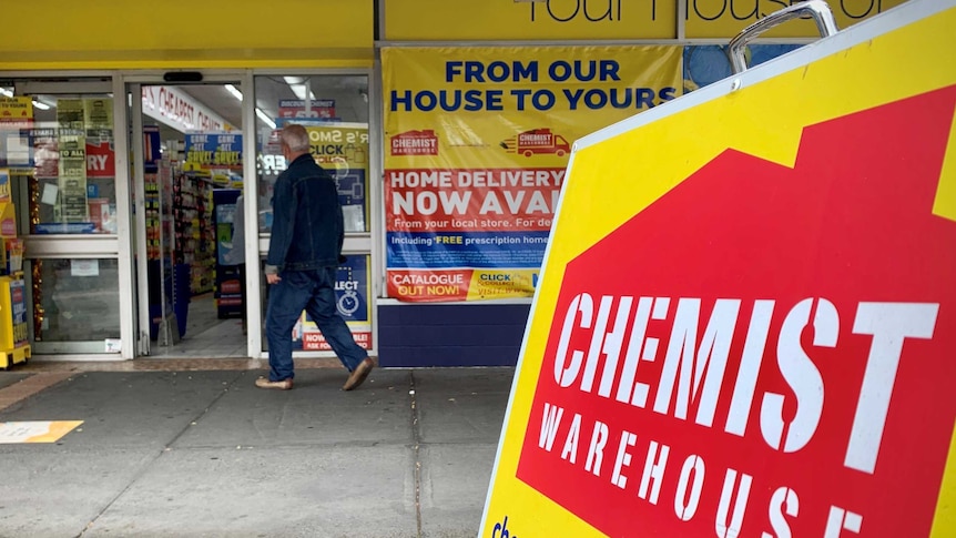 A man walks into a bright yellow Chemist Warehouse store.