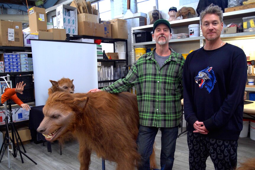 Adam and Damian, the creators of Odd Studio, stand with a huge wolf costume in their studio.