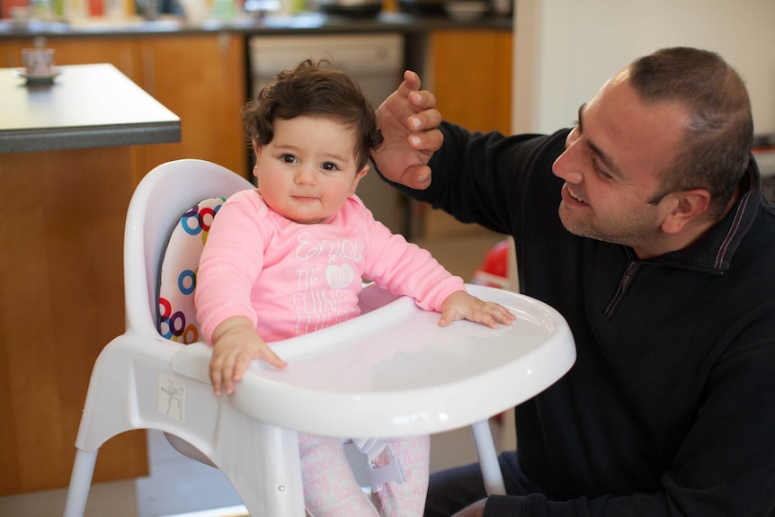 Mano smiles at and Hasmig who sits in a highchair