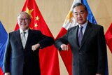 Philippine foreign minister and Chinese counterpart touch elbows in COVID-safe greeting.