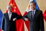 Philippine foreign minister and Chinese counterpart touch elbows in COVID-safe greeting.