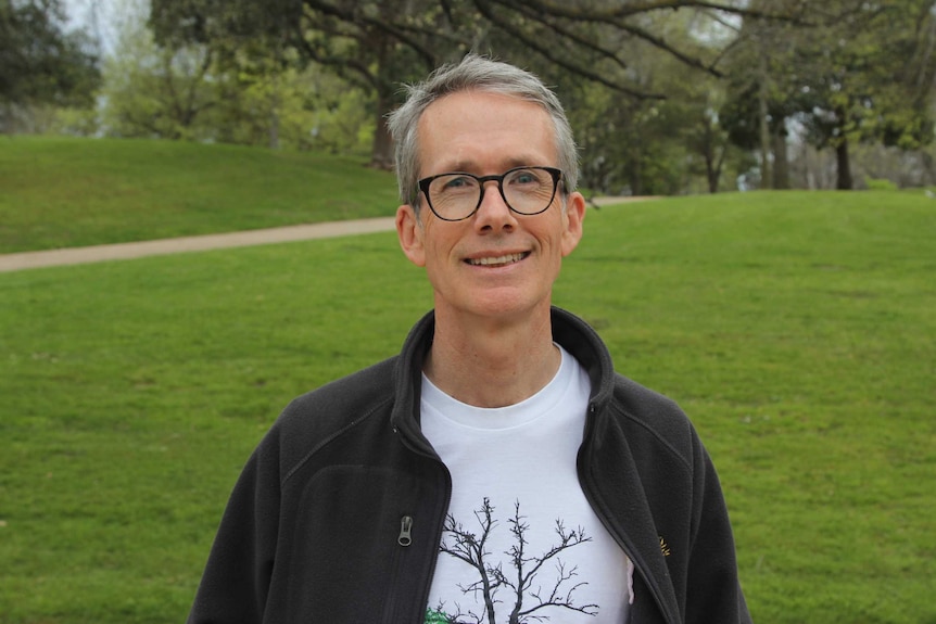 The CEO of the Melbourne's Royal Botanic Gardens Tim Enswisle looks at the camera while standing in the gardens.