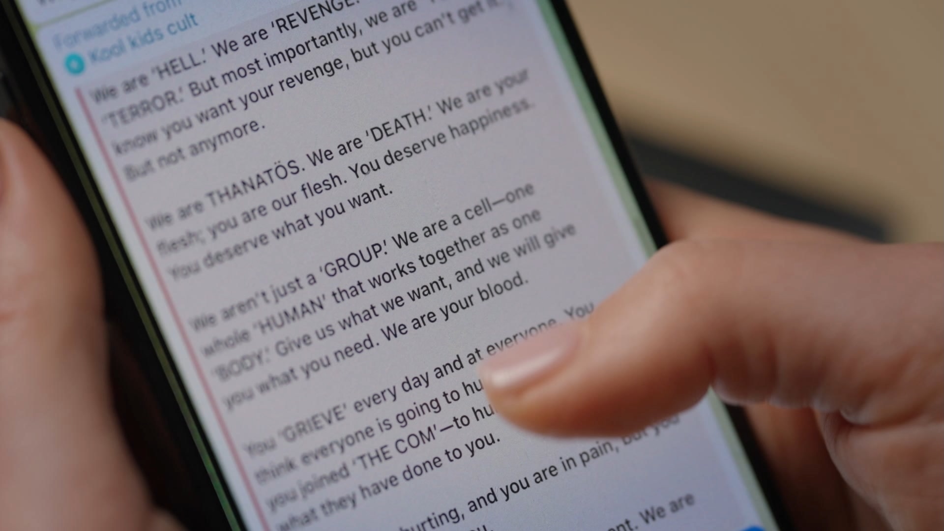 A girl's hands scrolling through messages on an iPhone.