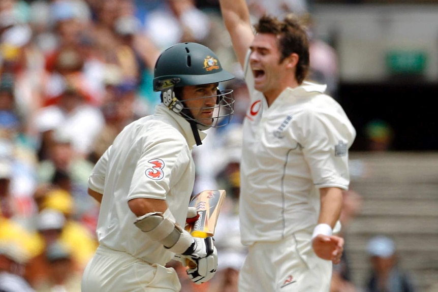 Australia batsman Justin Langer turns around as England bowler, blurred in the background, shouts with his hand in the air.