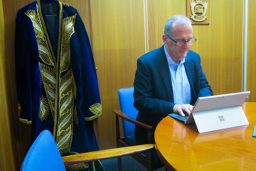 John Culleton looking at a computer, sitting in his Coleambally Irrigation office